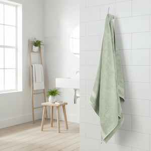 Lysegrønt bomullshåndkle brettet på hvit bakgrunn