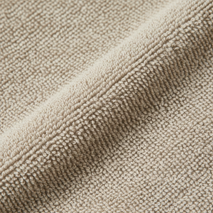 Nøytralt beige badehåndkle hengende i moderne baderom