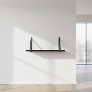Forno vegghylle sort med skinnstropper 80 x 20 cm, montert på lys vegg i interiørmiljø