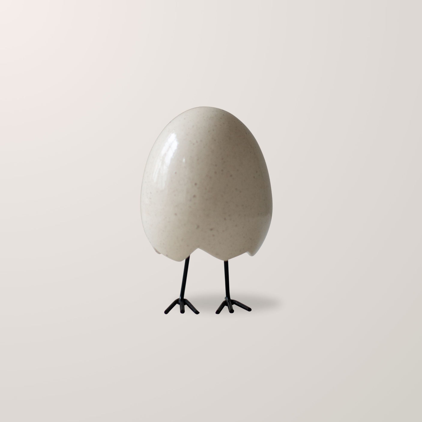 DBKD Tittei – keramisk eggfigur med små metallføtter og sjarmerende uttrykk.