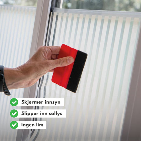 Vindusfolie med vertikale hvite striper montert på baderomsvinduer
