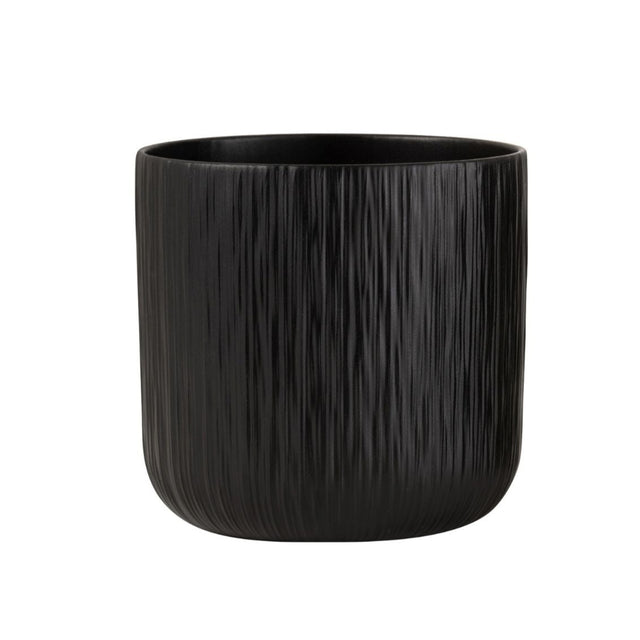 To sorte keramiske blomsterpotter, en glatt og en strukturert, på tregulv i moderne stueinteriør