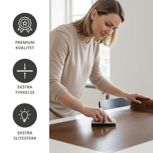 Montering av London Oak kontaktplast på bordplate – kvinne glatter kontaktplasten for et jevnt, slitesterkt og naturtro eikepreg.