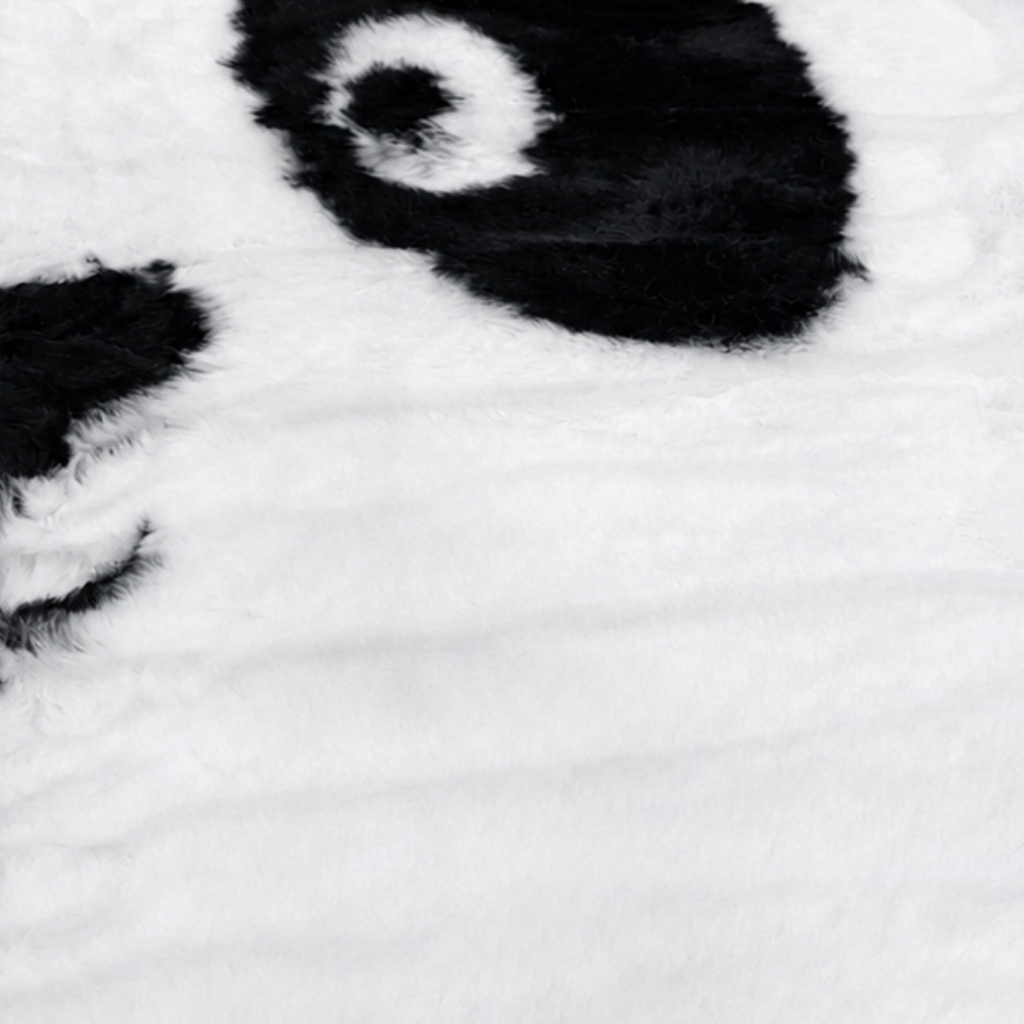 Nærbilde av mykt pandateppe i svart og hvitt med fluffy overflate i polyester, designet som et pandaansikt til barnerom.