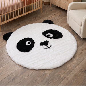 Rundt pandateppe i svart og hvitt på tregulv, mykt barneteppe med pandaansikt og 100 cm diameter til barnerom.