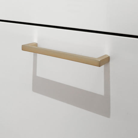 Nærbilde av messingfarget møbelhåndtak. 