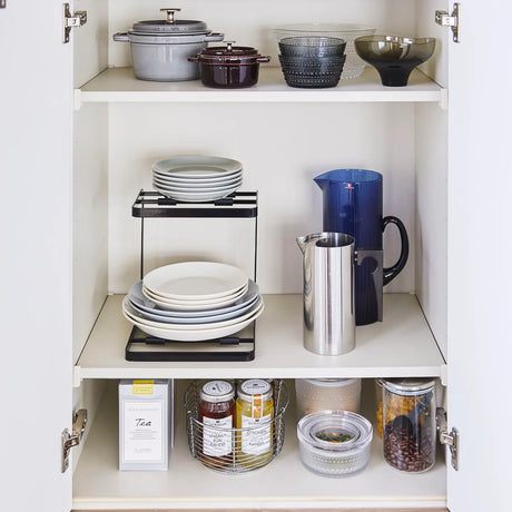 Kjøkkenorganisering med svart stativ for små gryter og lokk