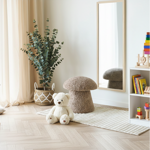 Brun puff i fuskepels plassert ved sofa i lyst interiør