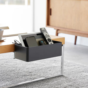 Svart bordmontert kurv til fjernkontroller, notatbøker og kabler