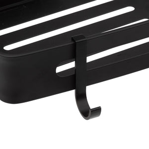 Detaljbild av en svart dusjhylle i aluminium med avtagbar krok och öppningar som tillåter att vattnet rinner igenom hyllen.