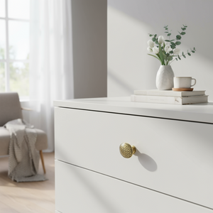 Detaljbilde av bronsefarget knott med mønster på lys overflate