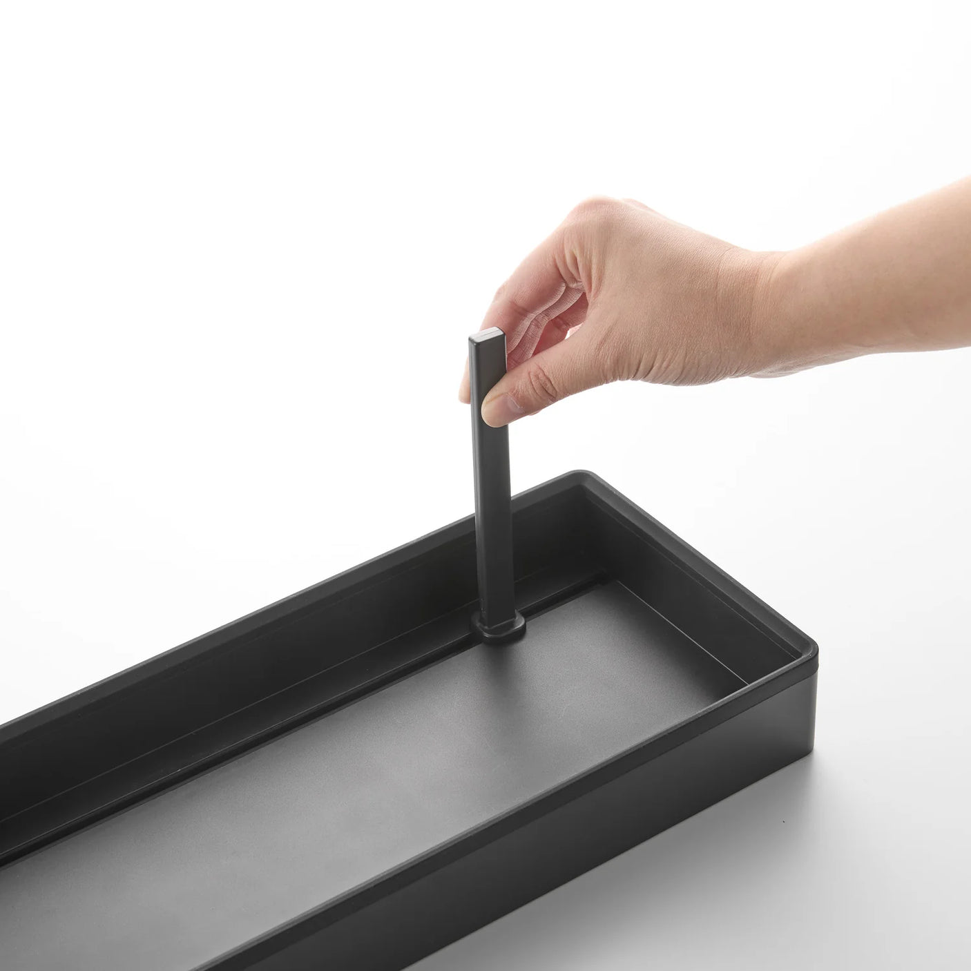 Produktet plassert i kjøkkenskap med gryter, lokk og tallerkener i bruk