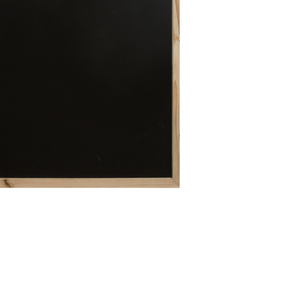 Nærbilde av svart krittflate og nederste treramme på husformet krittavle for barn.