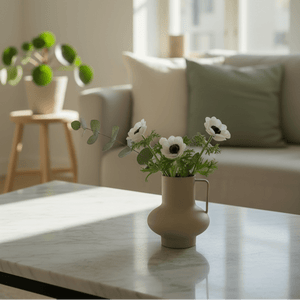 Matt sandfarget vase med håndtak brukt som borddekorasjon i moderne stue