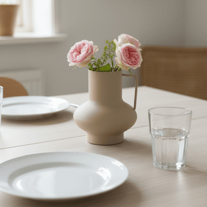 Matt sandfarget vase med rosa blomster som bordpynt på spisebord