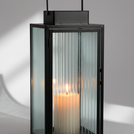 Lykter stripet glass på hagebord utendørs servering med stearinlys
