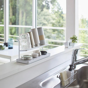 Hvitt stativ til lufttørking av flasker og tilbehør på benk