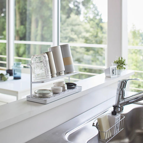 Hvitt stativ til lufttørking av flasker og tilbehør på benk