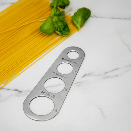 Porsjonsmåler for spaghetti i sølvfarget rustfritt stål på hvit bakgrunn