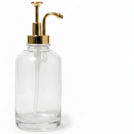 Klar glassdispenser med gullpumpe og avrundet form til sirup eller honning. - Lindas dekor