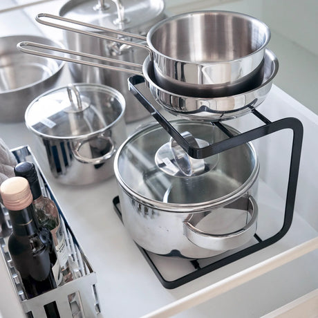 Svart stativ til kjøkkenskap med plass til gryter, lokk og redskaper nærbilde