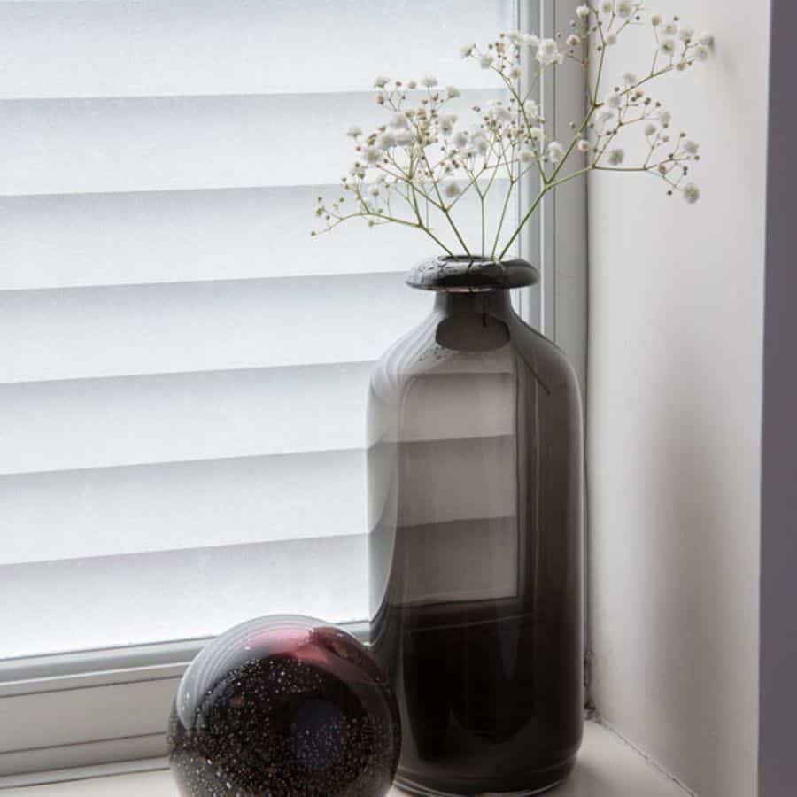 Vindusfolie med jalousimønster montert på vindu, perfekt til bad og soverom