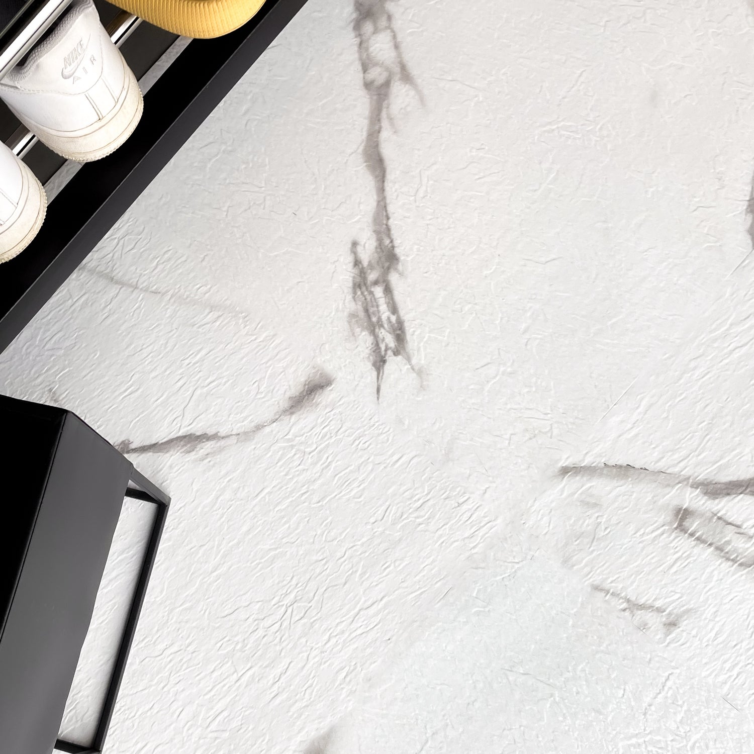 Hvite marmorgulvfliser selvklebende montert på gulv i moderne interiør"

