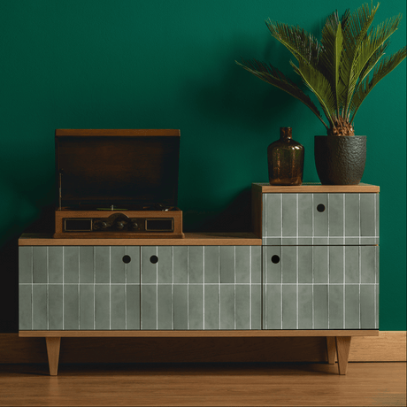 Kreativ bruk av grønne selvklebende fliser på skjenk i stue med mørk grønn vegg og dekor.