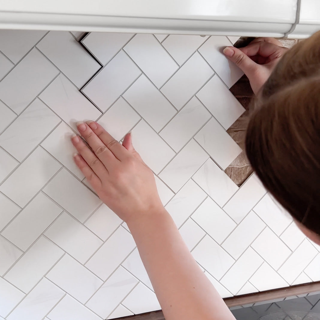 Stein fiskebein marmor veggfliser montert i klassisk fiskebeinsmønster.